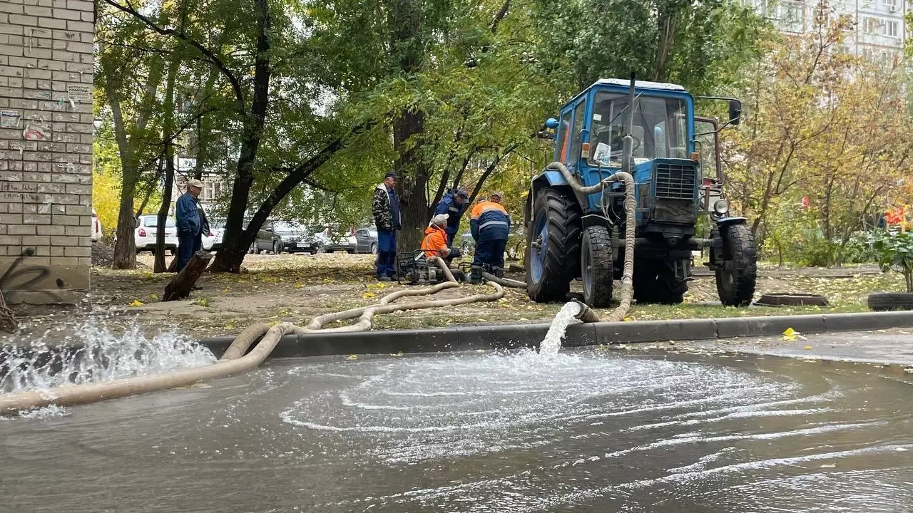 Трактор откачивает воду и сливает её на дорогу